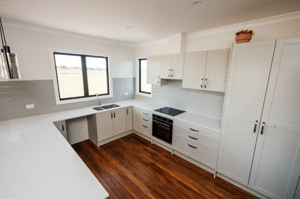 Kitchen renovated to look brand new with polished wooden floor and new cabinets