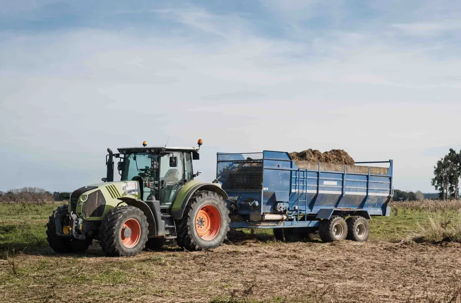 Tractor pulling silage wagon, silage stack bunker  storage area designed for efficient feed management