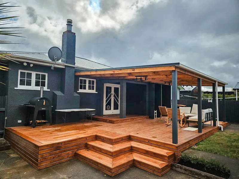 Completed deckstained with an orange tint and covered seated area and open BBQ area