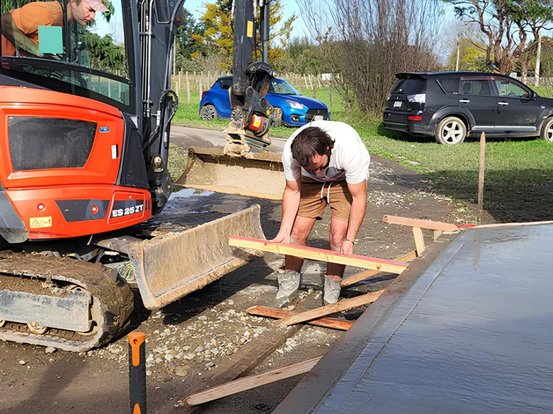Construction workers concreting an area on a house