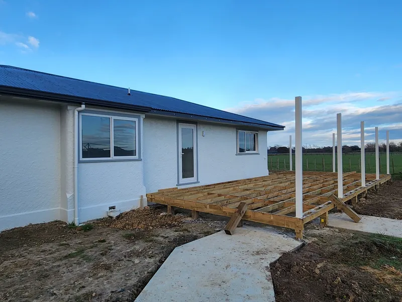 Deck under construction with new concrete path leading through the lawn to connect outdoor areas on residential property