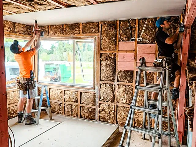 Builders working installing new insulation and re-jibbing a room