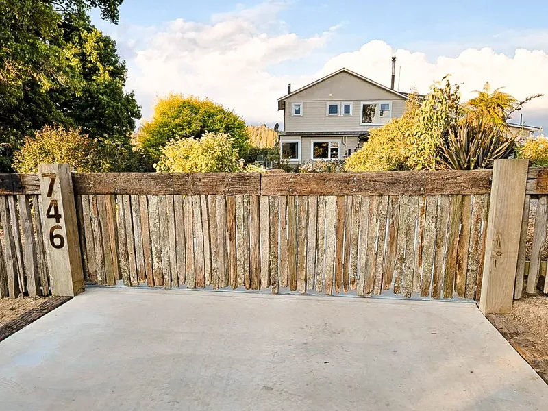 New concreted driveway with a stand out wooden gate using old fence battens