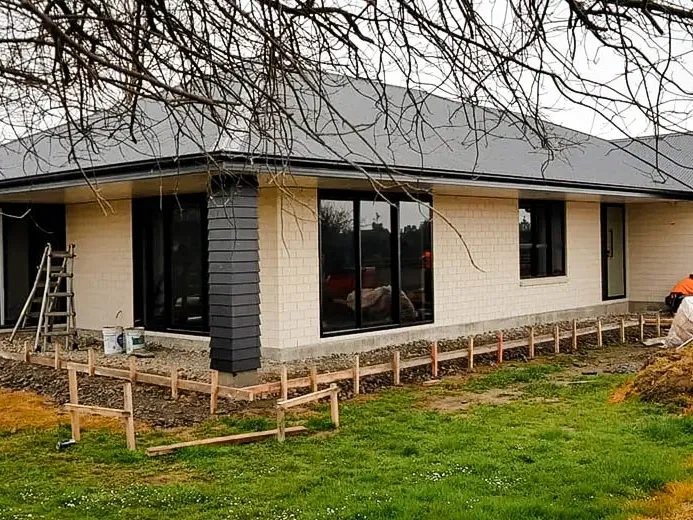 New house build with covered concrete pathway wrapping around the edge of the house