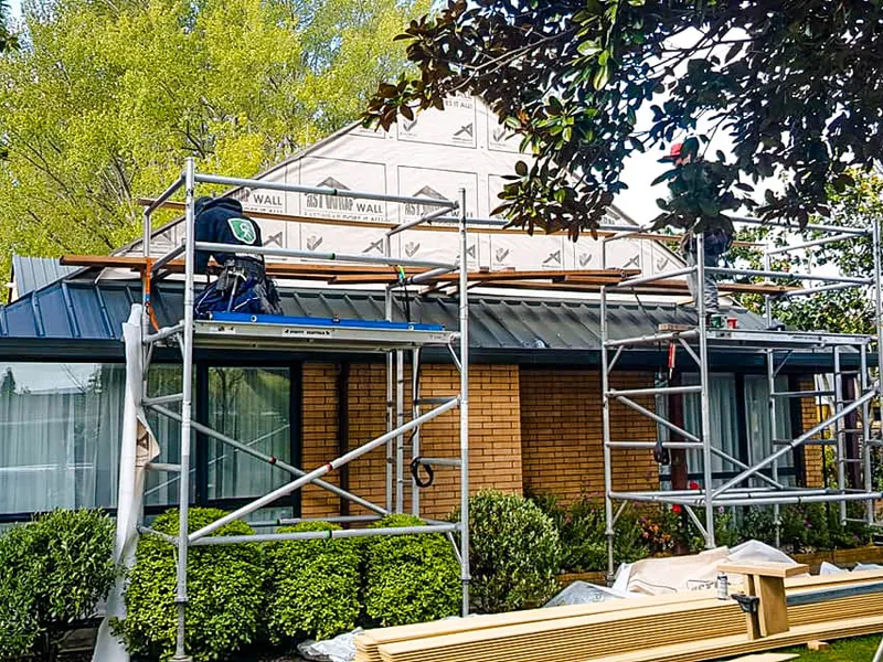Recladding house exterior construction to repair damaged house and restore weatherproofing