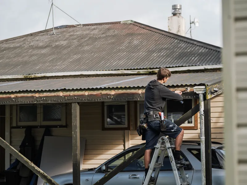 Builder removing old guttered to install new guttering to effectively manage the rainwater
