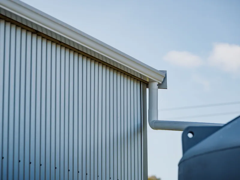 Guttering on the side of a pole shed draining water into the water tank