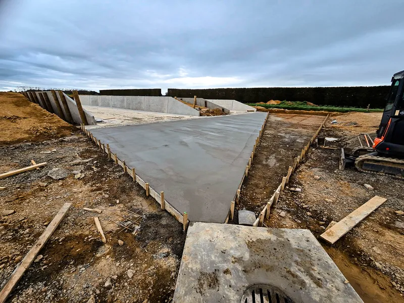Concrete area setting to reduce mud from machinery traffic when feeding out with drainage