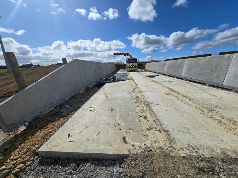 Concrete sloped wall panels set in place for optimal feed storage in silage bunker
