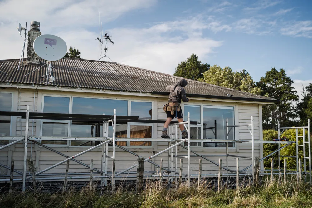 Manawatu builder walking on scaffolding working on a house renovation