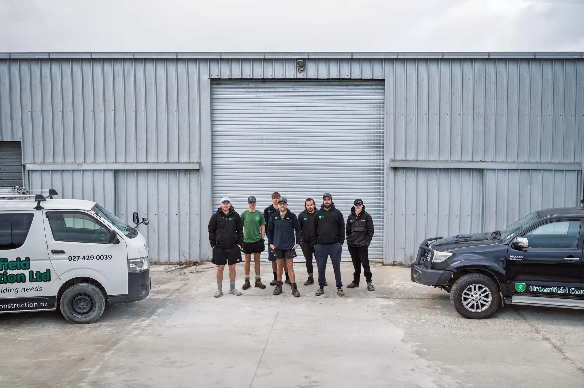 Greenfield Construction team outside the Greenfield workshop with the vehicles