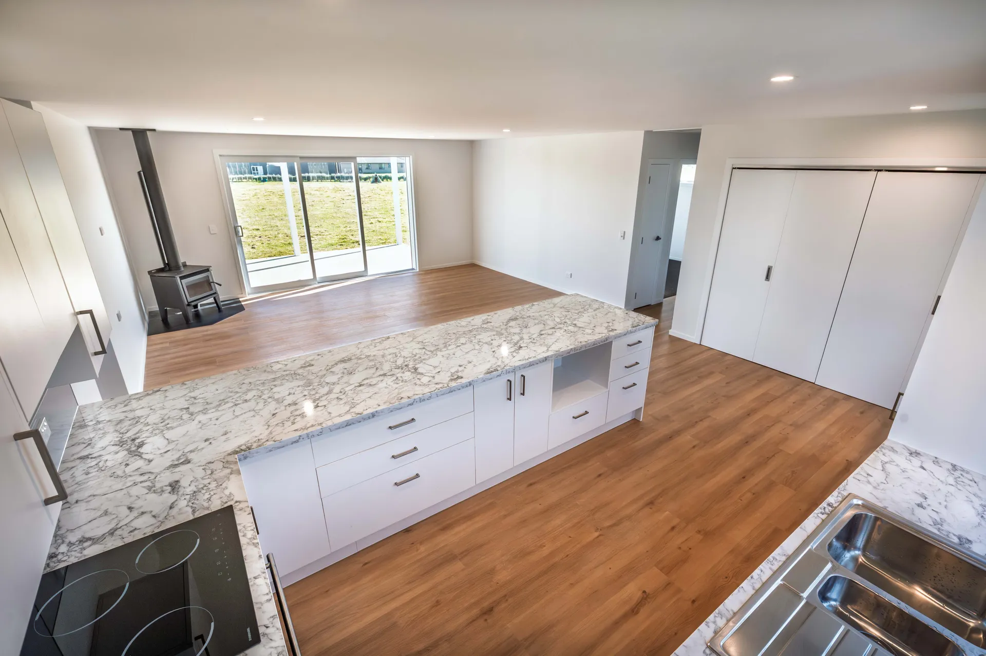 New house kitchen with fireplace and wood flooring and open place living